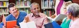 a group of mature adults discussing books in a library