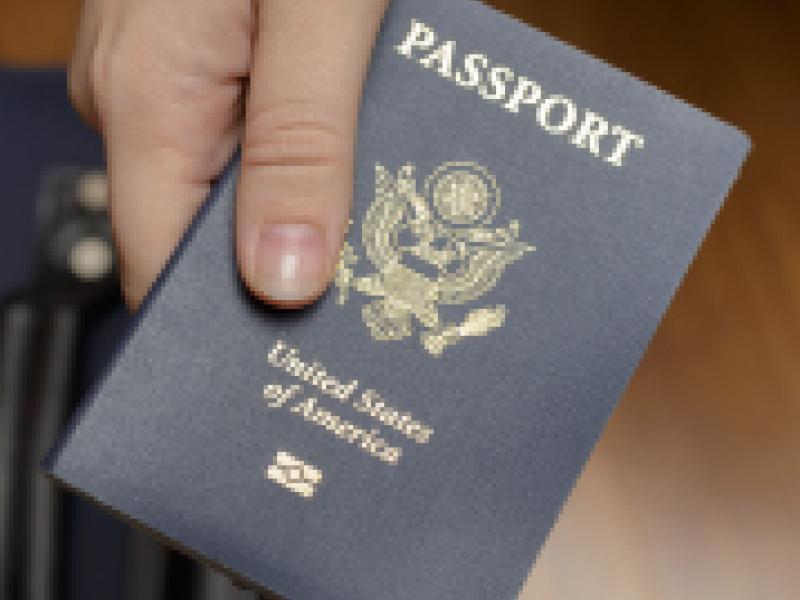 A hand holding a passport.