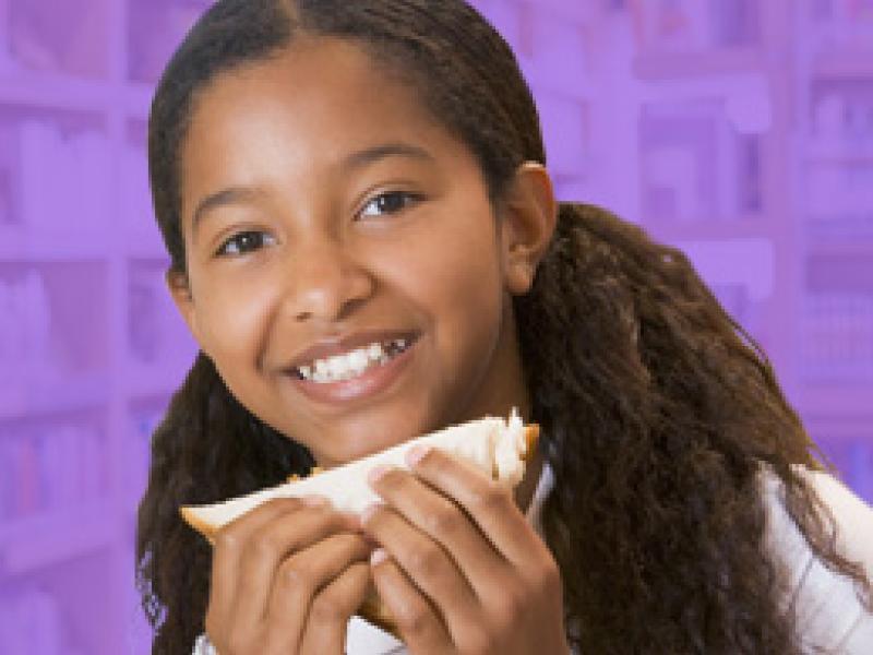 young girl holding a sandwich