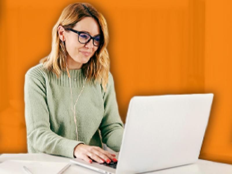 Image of a woman writing on a laptop