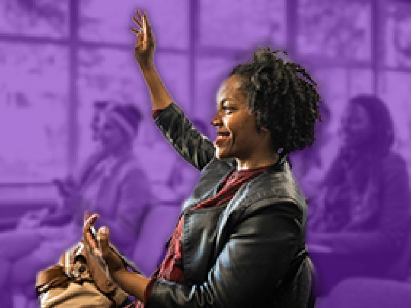 Woman raising hand at community meeting