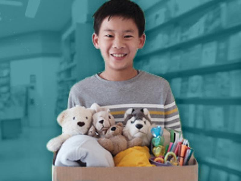 Young boy holding a box of donations