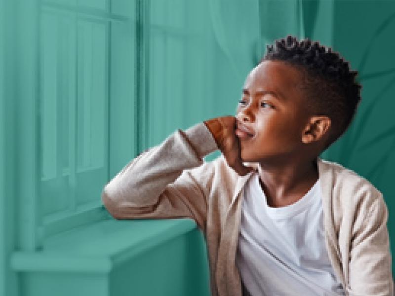 Young boy, looking bored, staring out the window