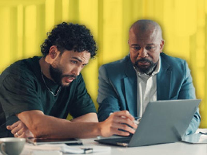 two men working on a laptop