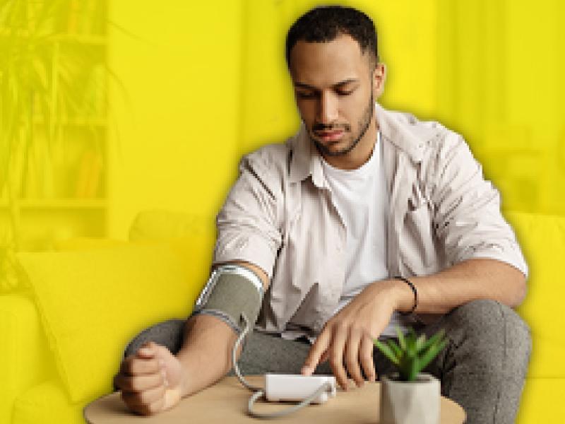 a man using a home blood pressure machine