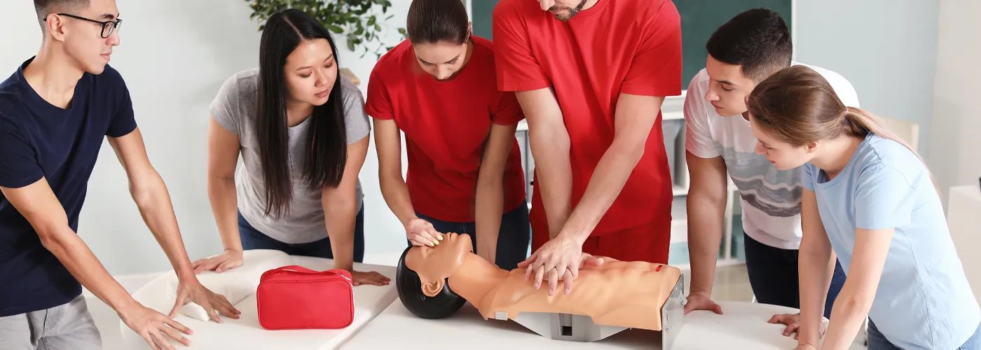 group of people learning CPR on a medical dummy