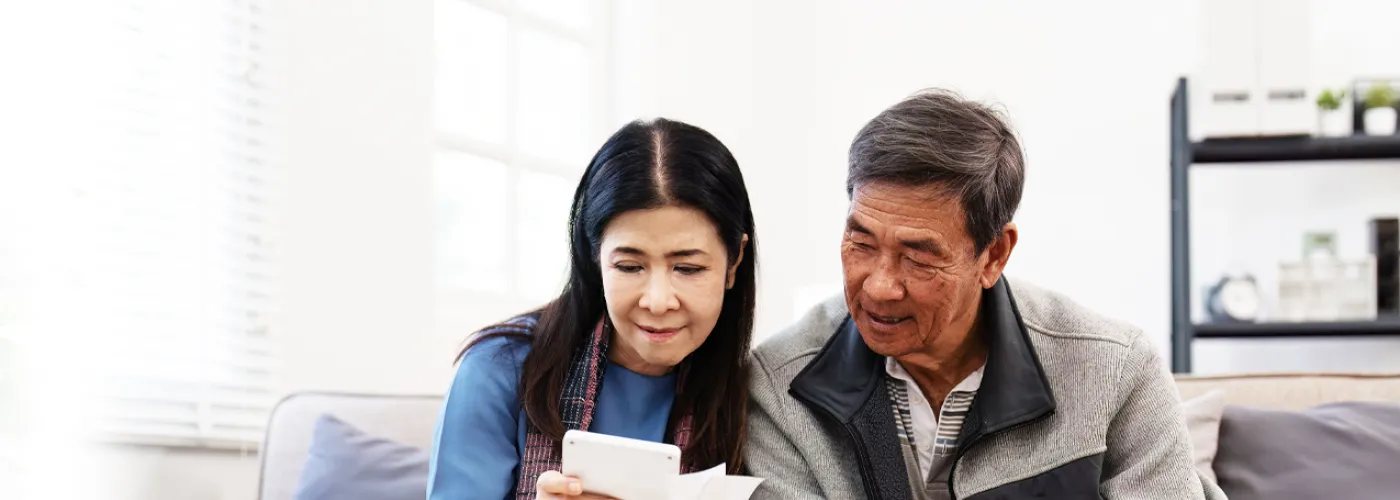 photo of an elderly couple looking at a calculator