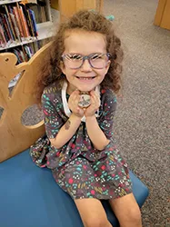 Small girl sitting on a bench and smiling