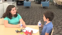 Smiling kids eating snacks and drinking water at a table
